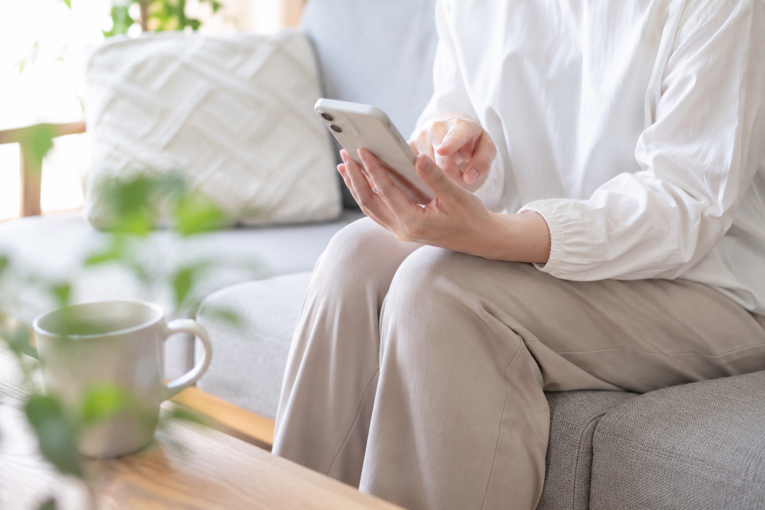 自宅でスマートフォンから住宅会社へ問い合わせをしている様子